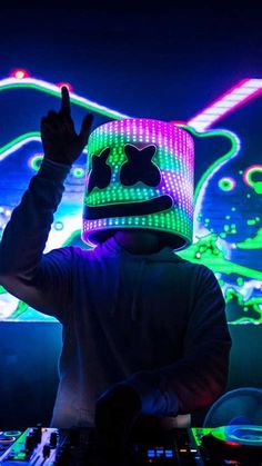 a person wearing a hat and dj equipment in front of a sound board with neon lights