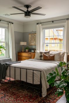 a bedroom with a bed, dresser and window in it's centerpieces