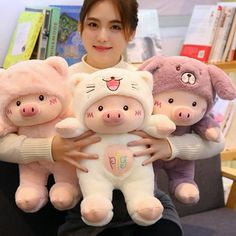 a woman holding three stuffed animals in her hands