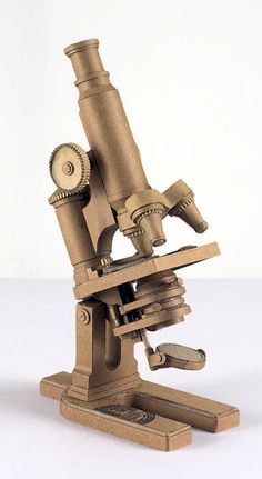 a wooden model of a microscope on a white background