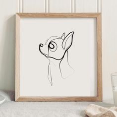 a black and white drawing of a dog in a frame next to a glass of milk