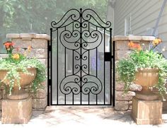 an iron gate with two planters in front of it