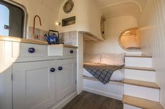 the interior of a tiny house with stairs leading up to it's bed area