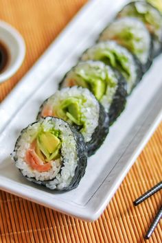 sushi rolls with avocado, tomato and cucumber on a white plate