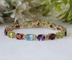 Simple and colorful vintage 14K yellow gold bracelet with natural multi gemstones. Blue topaz, purple amethyst, green peridot, and deep red garnets are open back allowing for the ultimate light reflection. A slide clasp with an accompanying pin safety catch completes the piece. Stunning to wear alone for just a little color or great stacked and layered with others! This Bracelet can be made with your desired gemstone as well. x If you would prefer a custom Bracelet, please contact us before purc Luxury Multicolor Beaded Bracelets As Gift, Affordable Vintage Gold Stretch Bracelet, Christmas Gift Handmade, Multi Gemstone Bracelet, Colorful Bracelet, Custom Bracelet, Gold Armband, Wedding Jewelry Bracelets, Stacked Jewelry