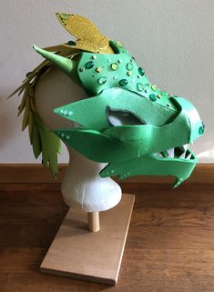 a green dragon mask on a mannequin head