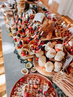 a table filled with lots of different types of food on top of wooden trays