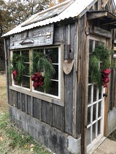 an old wooden building with wreaths on the windows