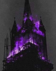 a large clock tower with purple lights on it's face and the sky in the background