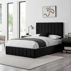 a bedroom with white walls and black furniture