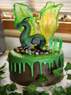 a cake with green icing and a dragon figurine sitting on top of it