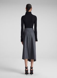 The Clara Skirt is crafted from a pinstripe wool cashmere in a grey melange hue. This asymmetrical midi skirt features a mid-rise relaxed waist with a wrap silhouette and ruched detailing at the hip. This style runs true to size. Shop Bottoms. Styling Tip: Tuck a slim knit into the skirt and polish off with square-toe boots. Asymmetrical Midi Skirt, Square Toe Boots, Toe Boots, Gray Skirt, Landscaping, Mid Rise, Midi Skirt, Cashmere, Wool