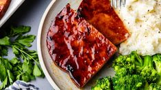 a plate with broccoli, mashed potatoes and meat covered in bbq sauce