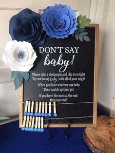 a sign that says don't say baby with paper flowers and matches on it