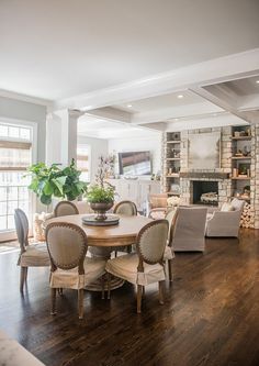 a dining room table and chairs in front of a fireplace