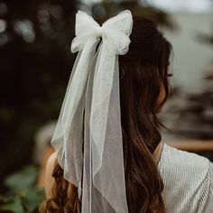 a woman wearing a white veil with a bow on her head