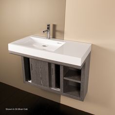 a bathroom sink sitting under a mirror next to a wall mounted faucet and cabinet