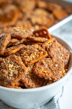 a white bowl filled with fried pretzels on top of a blue and white towel