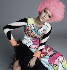 a woman with pink hair sitting on top of a black and white floor next to a gray wall