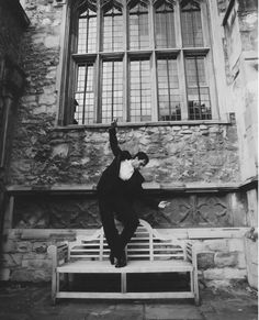 a man in a tuxedo jumping on a bench