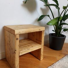 a wooden step stool next to a potted plant