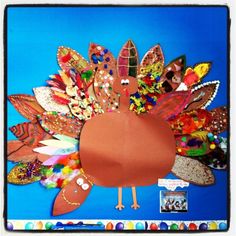 a turkey made out of different colored feathers on a blue background with other items around it