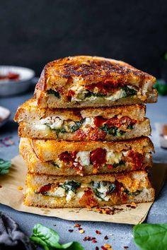 four slices of pizza stacked on top of each other with basil leaves around the edges