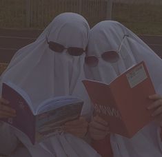 two people in white headscarves are reading books