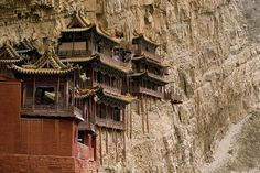 an ornate building on the side of a cliff