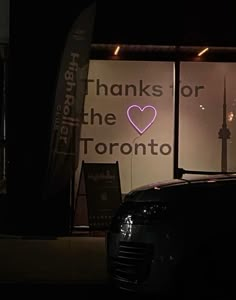 a car parked in front of a window with a pink heart on it's side