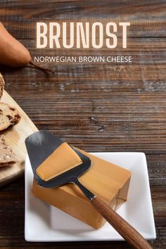 a wooden table with bread and cheese on it next to a spatula that says, bruniost norwegian brown cheese