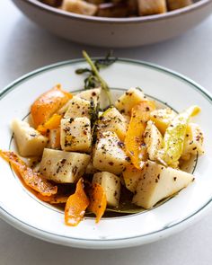 a white plate topped with potatoes and orange slices