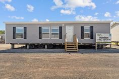 a mobile home sits in the middle of a dirt lot