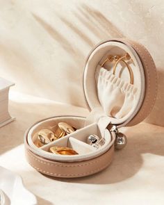 an open jewelry box with rings inside on a table next to a stack of books