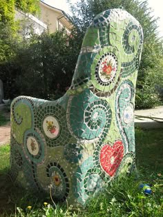 a mosaic dog statue sitting in the grass