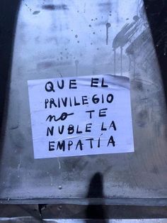 a sign that is on the side of a metal object with writing written in spanish