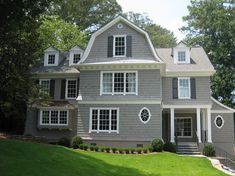 a large gray house with white trim and windows