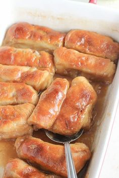 a casserole dish filled with meat and gravy being spooned into it