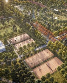 an aerial view of tennis courts surrounded by trees