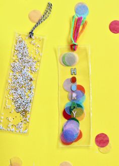 some crafting supplies are laying out on a yellow surface with confetti and sprinkles