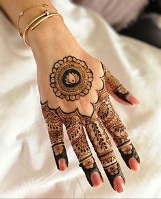 a woman's hand with henna tattoos on it