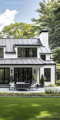 a large white house with lots of windows on it's roof and patio area