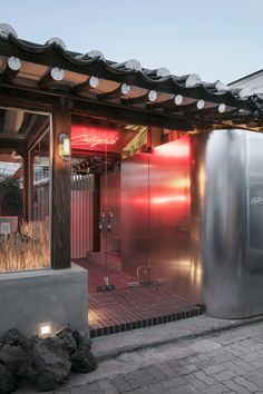 an outdoor hot tub in front of a building with red lights on the roof and windows