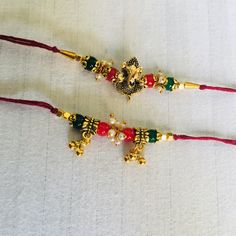 two red and green beaded bracelets sitting on top of a white tablecloth