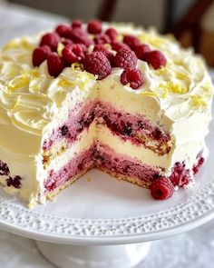 a white cake with raspberries and cream frosting