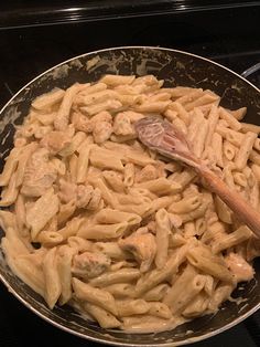 a pan filled with pasta and chicken on the stove