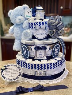 a blue and white diaper cake with a teddy bear on top