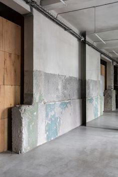 an empty parking garage with concrete walls and wood doors