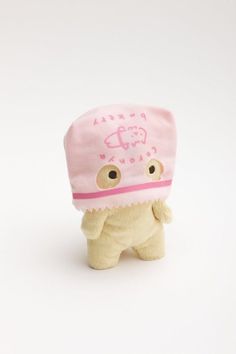 a small stuffed animal with a pink hat on top of it's head and eyes