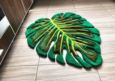 a green rug on the floor with a large leaf shaped design in front of it